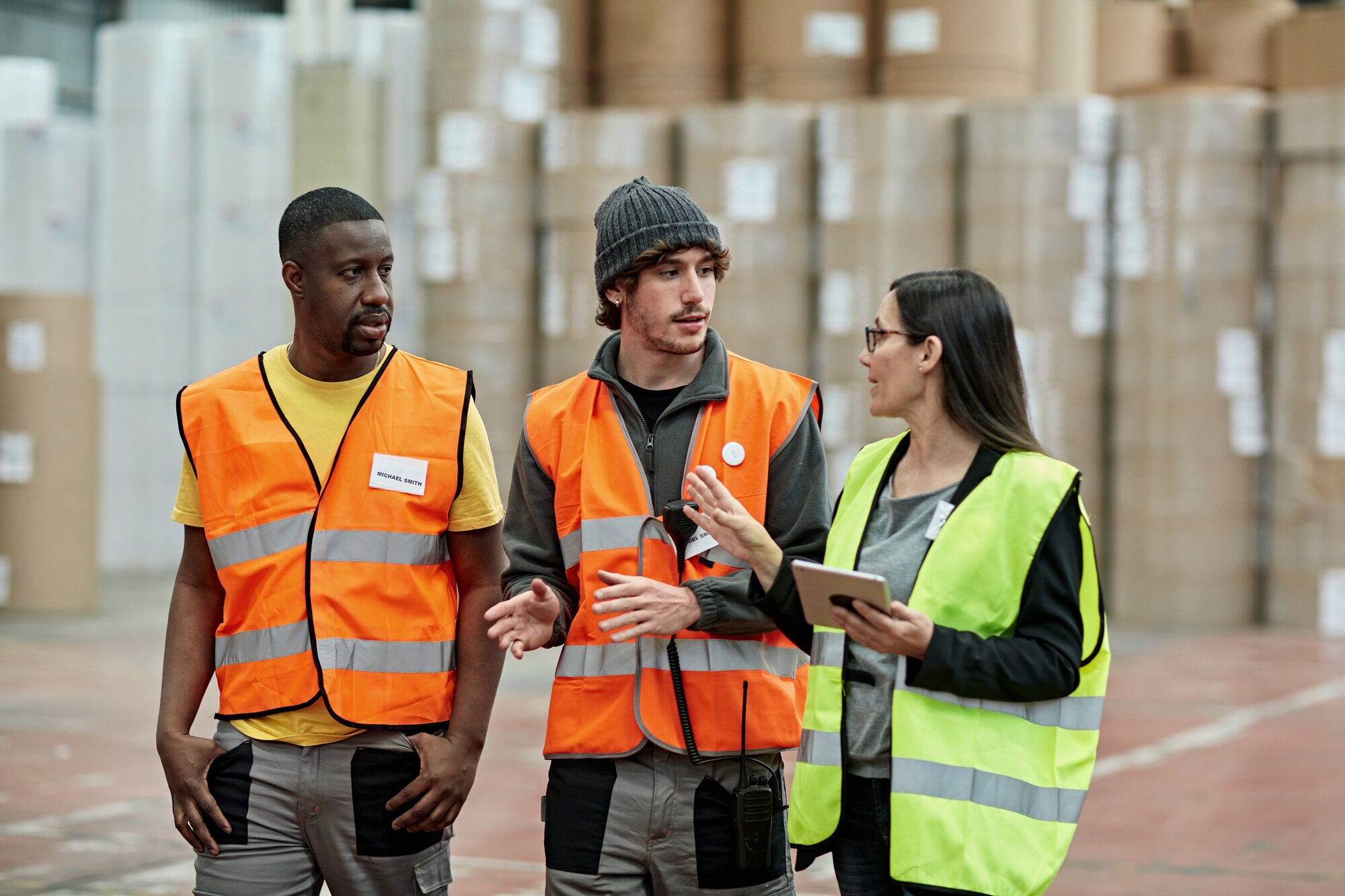 Workers in reflective vests walking with their supervisor on site